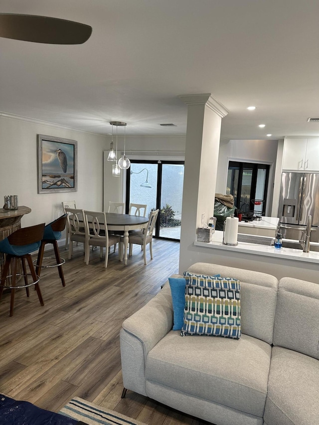 living room with hardwood / wood-style floors, crown molding, and sink