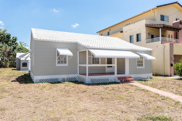 view of front of home featuring a balcony and a front lawn