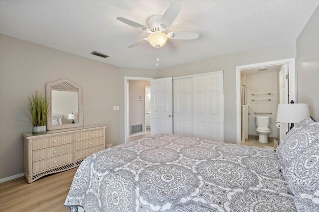 bedroom featuring a closet, ceiling fan, light wood-type flooring, connected bathroom, and a textured ceiling