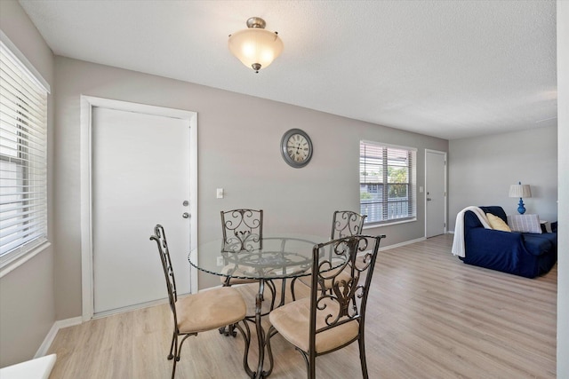 dining room featuring a textured ceiling and light wood-type flooring