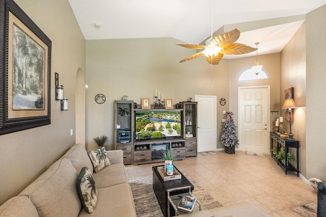 living room featuring ceiling fan, light tile patterned flooring, and lofted ceiling