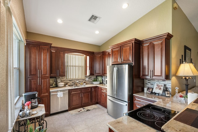 kitchen with backsplash, sink, vaulted ceiling, a healthy amount of sunlight, and stainless steel appliances