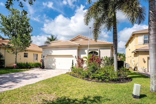 mediterranean / spanish-style house featuring a front yard and a garage