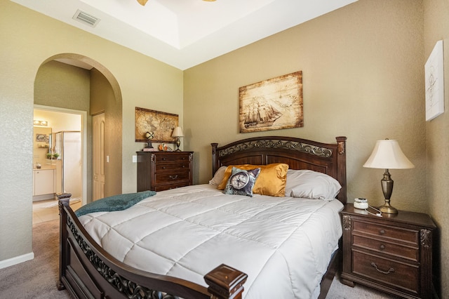 carpeted bedroom featuring ceiling fan and ensuite bath