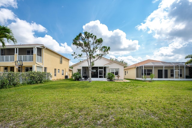 rear view of house with a yard and a lanai