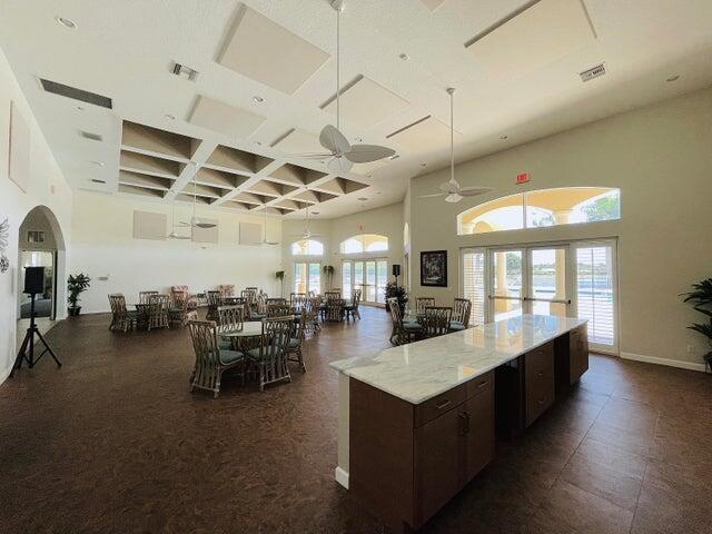 kitchen featuring dark brown cabinetry, ceiling fan, french doors, and a towering ceiling