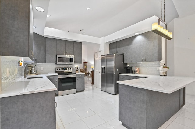 kitchen featuring stainless steel appliances, sink, decorative backsplash, and kitchen peninsula