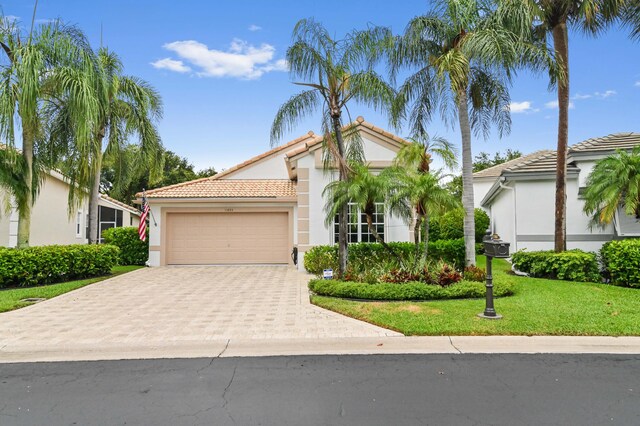 mediterranean / spanish-style home with a garage and a front yard