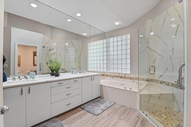 bathroom featuring hardwood / wood-style floors, vanity, and plus walk in shower