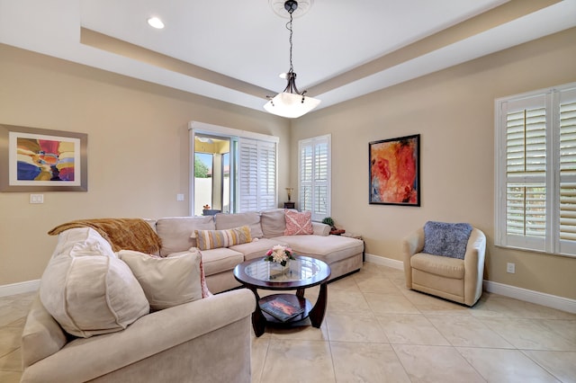 living room featuring light tile patterned floors, a wealth of natural light, and a raised ceiling