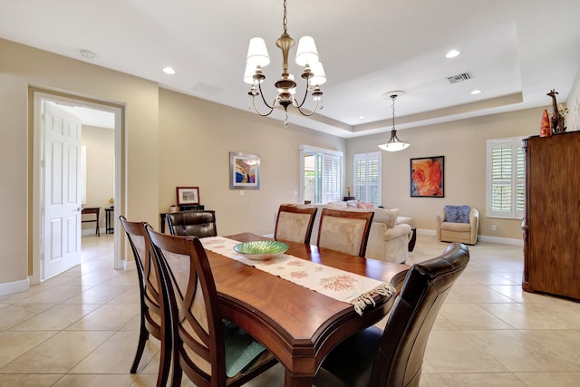 dining room with a wealth of natural light, a tray ceiling, and visible vents