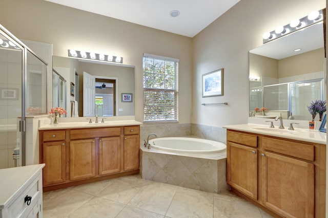 bathroom with a sink, a stall shower, a garden tub, and two vanities