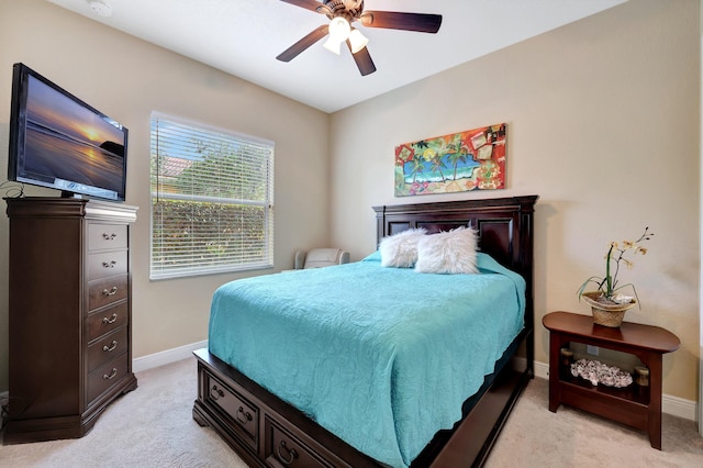 bedroom featuring a ceiling fan, light colored carpet, and baseboards