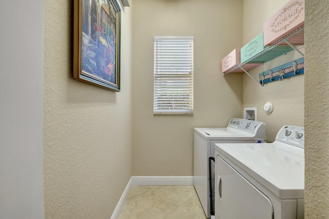 clothes washing area featuring light tile patterned flooring and separate washer and dryer