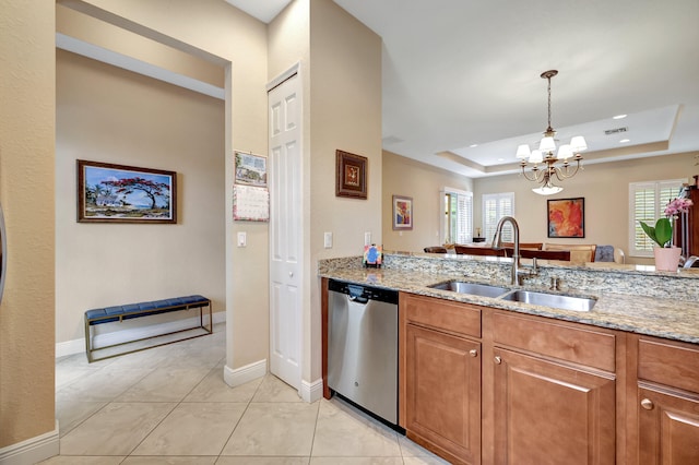 kitchen with light stone counters, a sink, visible vents, stainless steel dishwasher, and a tray ceiling