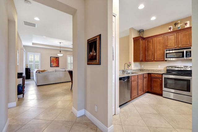 kitchen with light stone countertops, light tile patterned floors, stainless steel appliances, and sink