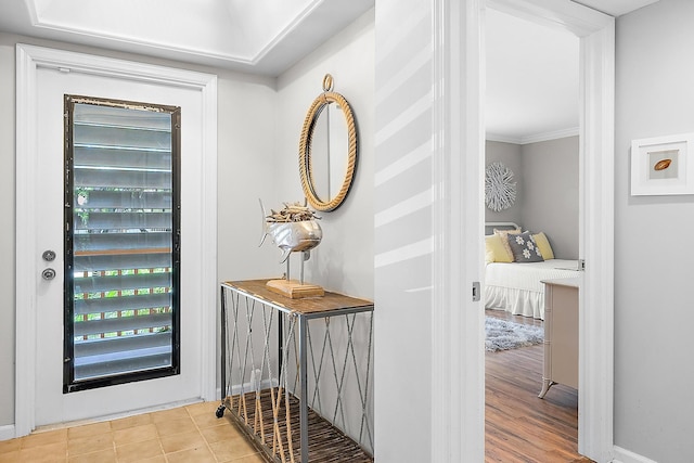 entryway with light hardwood / wood-style floors and crown molding