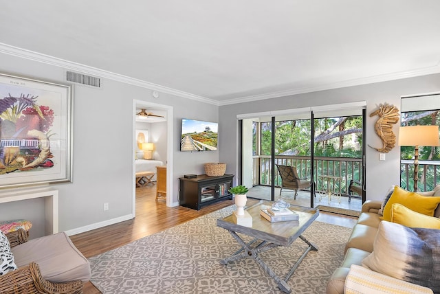 living room featuring crown molding, hardwood / wood-style floors, and ceiling fan