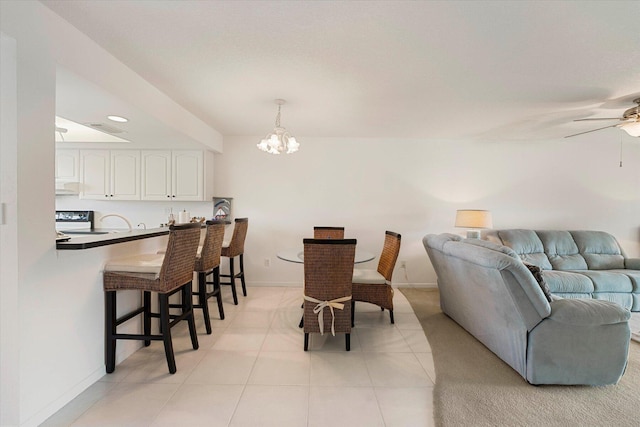 dining area featuring ceiling fan with notable chandelier and light tile patterned flooring