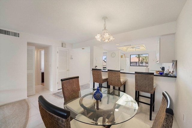 1600 NE Dixie Hwy Unit 10-205, Jensen Beach, FL 34957 - dining room featuring light tile patterned floors, baseboards, and a chandelier