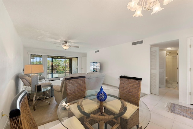 dining room featuring light tile patterned floors and ceiling fan with notable chandelier