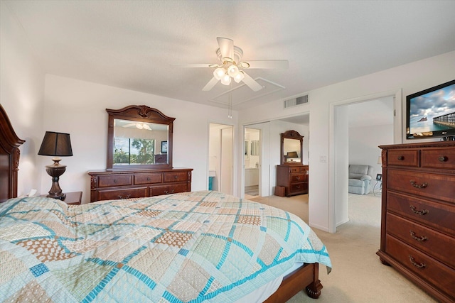 carpeted bedroom with ceiling fan and ensuite bath