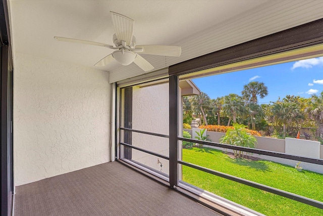 unfurnished sunroom with ceiling fan