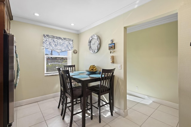 dining space featuring light tile patterned floors and ornamental molding