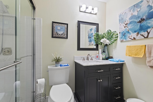 bathroom featuring vanity, an enclosed shower, and toilet