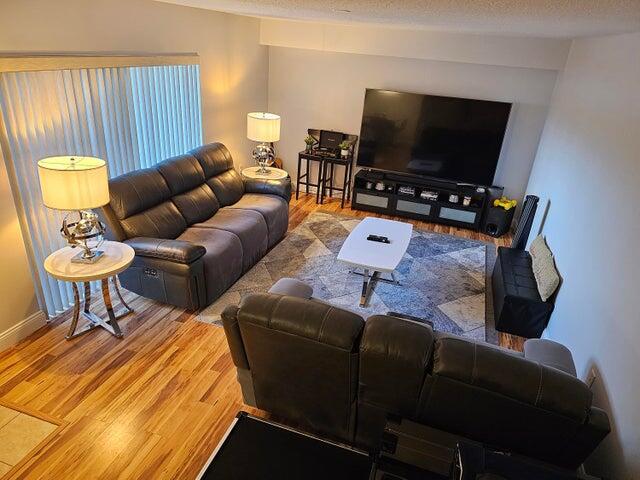 living room with a textured ceiling and hardwood / wood-style flooring