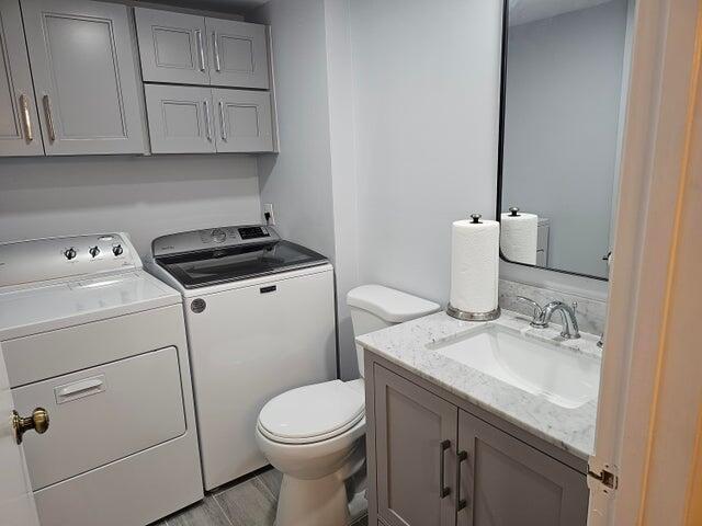 bathroom featuring vanity, toilet, independent washer and dryer, and wood-type flooring