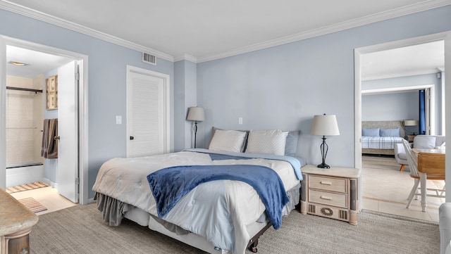 tiled bedroom featuring crown molding and ensuite bath