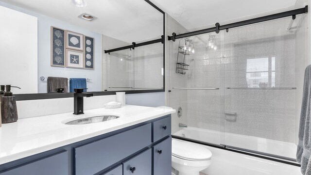 full bathroom with shower / bath combination with glass door, vanity, and toilet