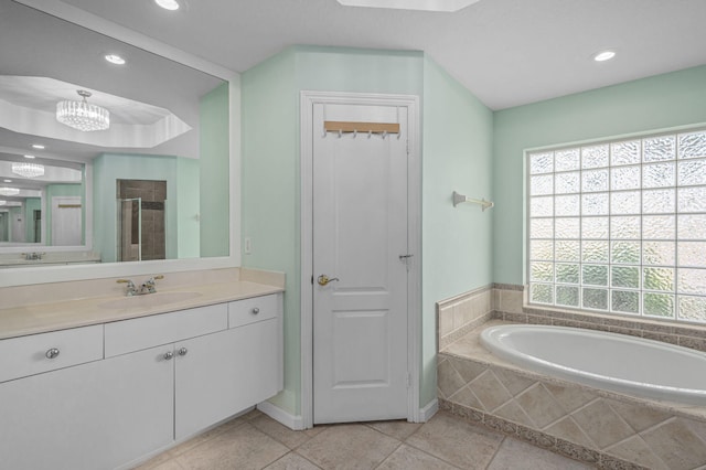 bathroom featuring tile patterned flooring, shower with separate bathtub, and vanity