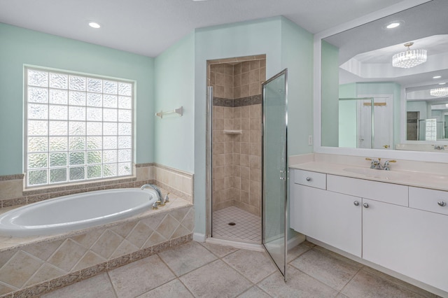 bathroom featuring plus walk in shower, vanity, and tile patterned flooring