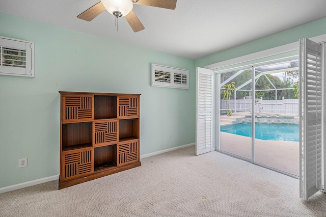 interior space with carpet flooring, access to exterior, and ceiling fan