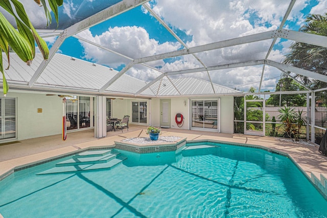 view of swimming pool with glass enclosure and a patio area