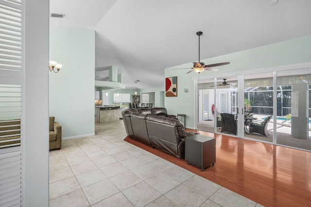 tiled living room with ceiling fan and lofted ceiling