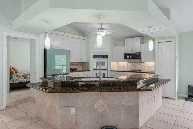 kitchen featuring white cabinetry, a large island, sink, and refrigerator