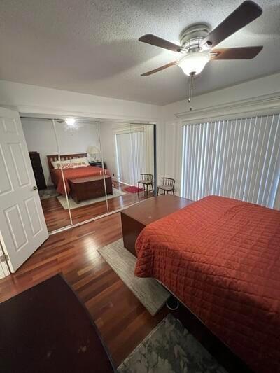 bedroom featuring a textured ceiling, a closet, ceiling fan, and hardwood / wood-style flooring