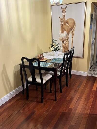 dining space featuring dark wood-type flooring and a chandelier