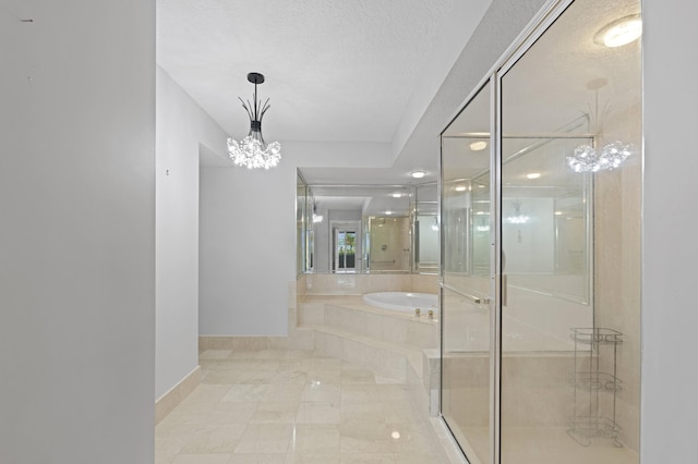 bathroom with a chandelier, a textured ceiling, and independent shower and bath