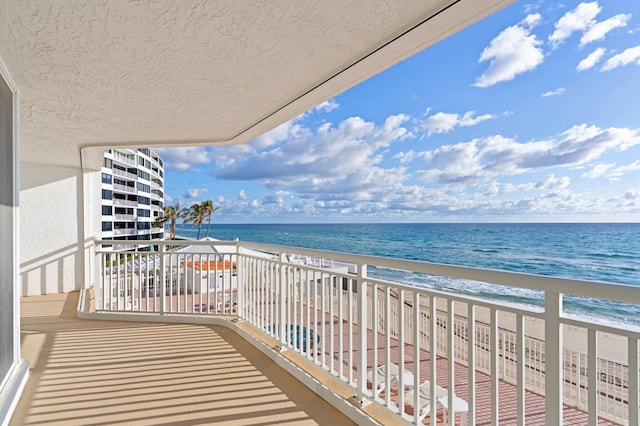 balcony featuring a water view and a view of the beach