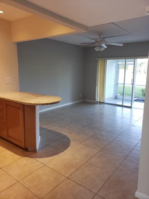 tiled empty room with ceiling fan