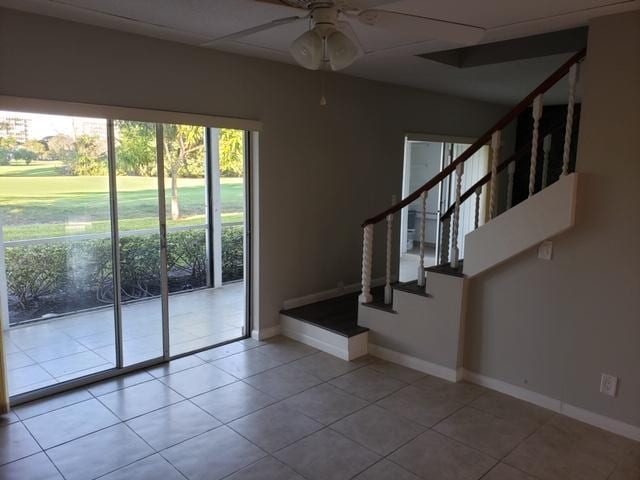 doorway featuring ceiling fan and light tile patterned flooring