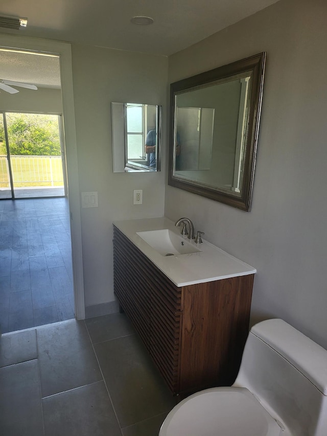 bathroom with vanity, toilet, and ceiling fan