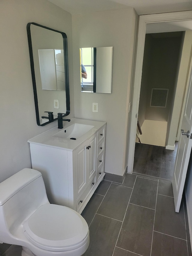 bathroom featuring tile patterned floors, vanity, and toilet