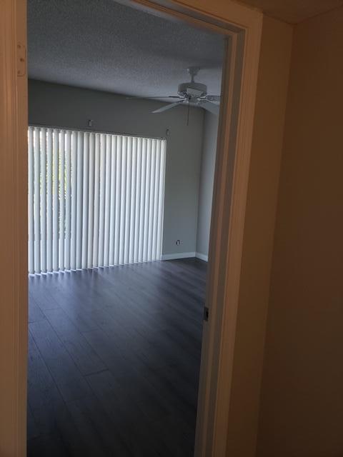 unfurnished room with a textured ceiling, hardwood / wood-style flooring, plenty of natural light, and ceiling fan