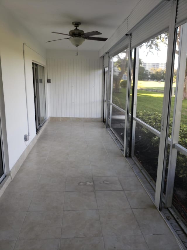 unfurnished sunroom with ceiling fan