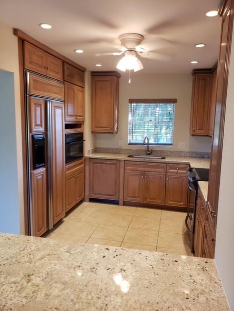 kitchen with ceiling fan, sink, light tile patterned floors, and black appliances